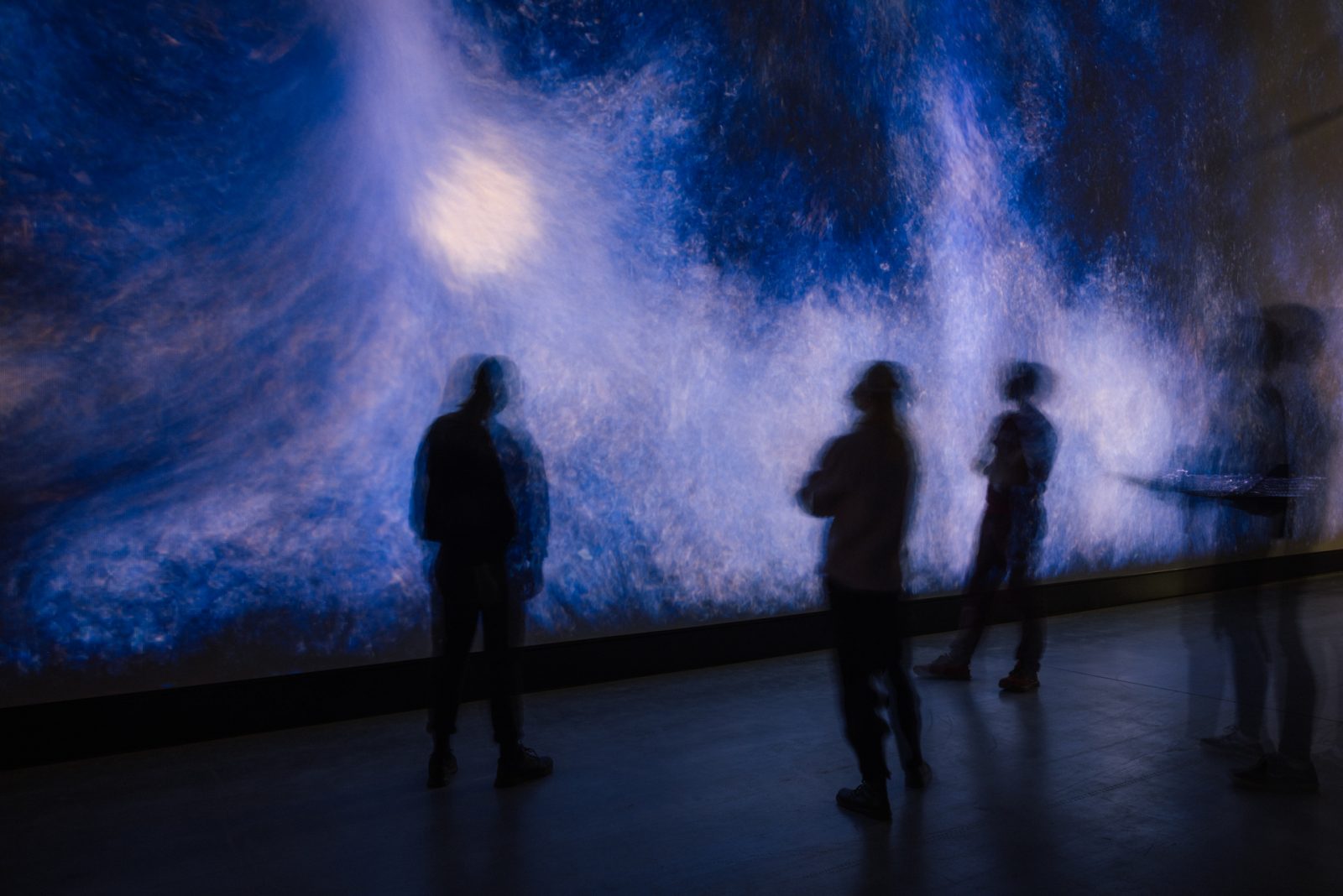 Henkilöitä valotaideteoksen edessä.
