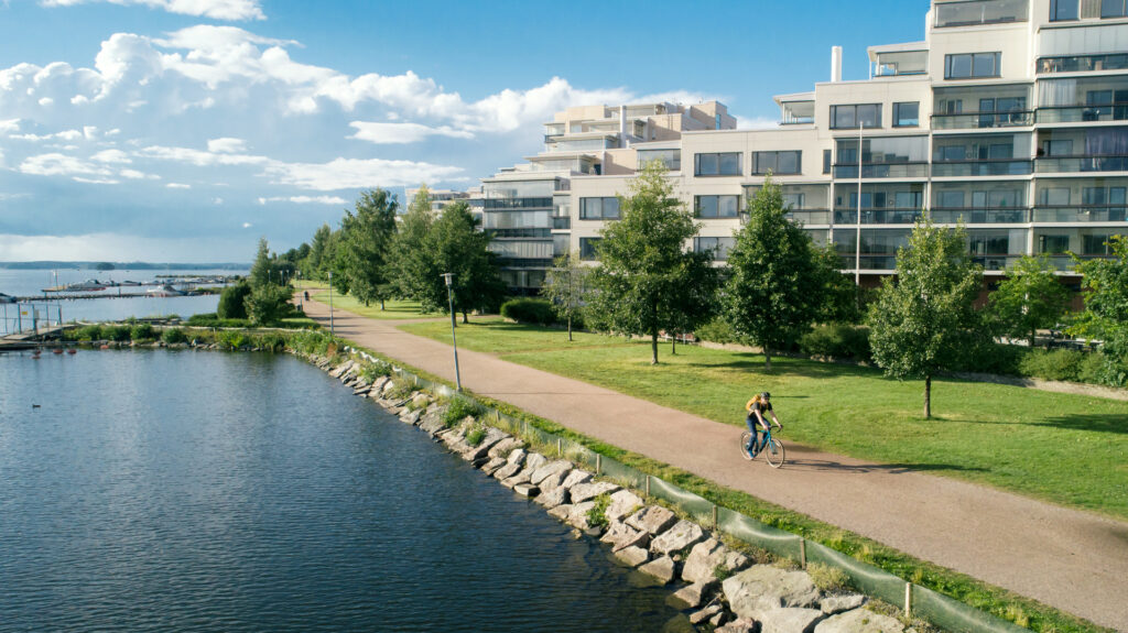 Pyöräilijä ajaa Ankkurin rantaa kesäisessä auringonpaisteessa.