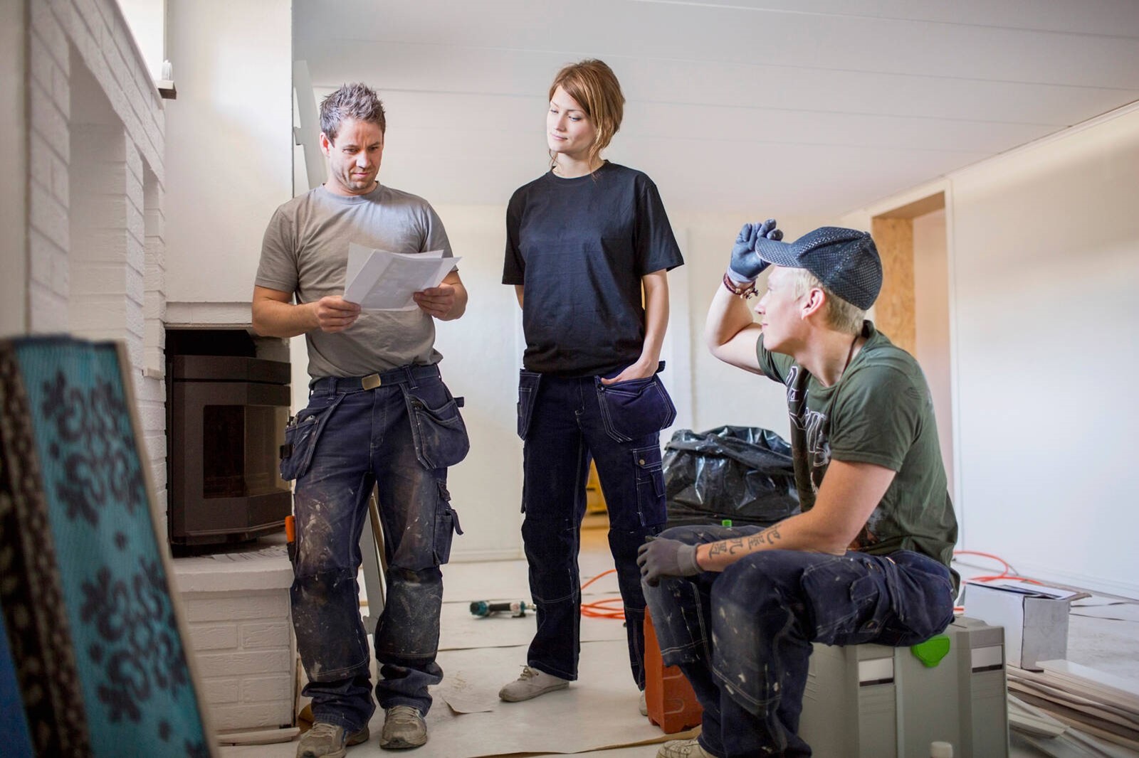 Kolme henkilöä pientalon työmaalla.