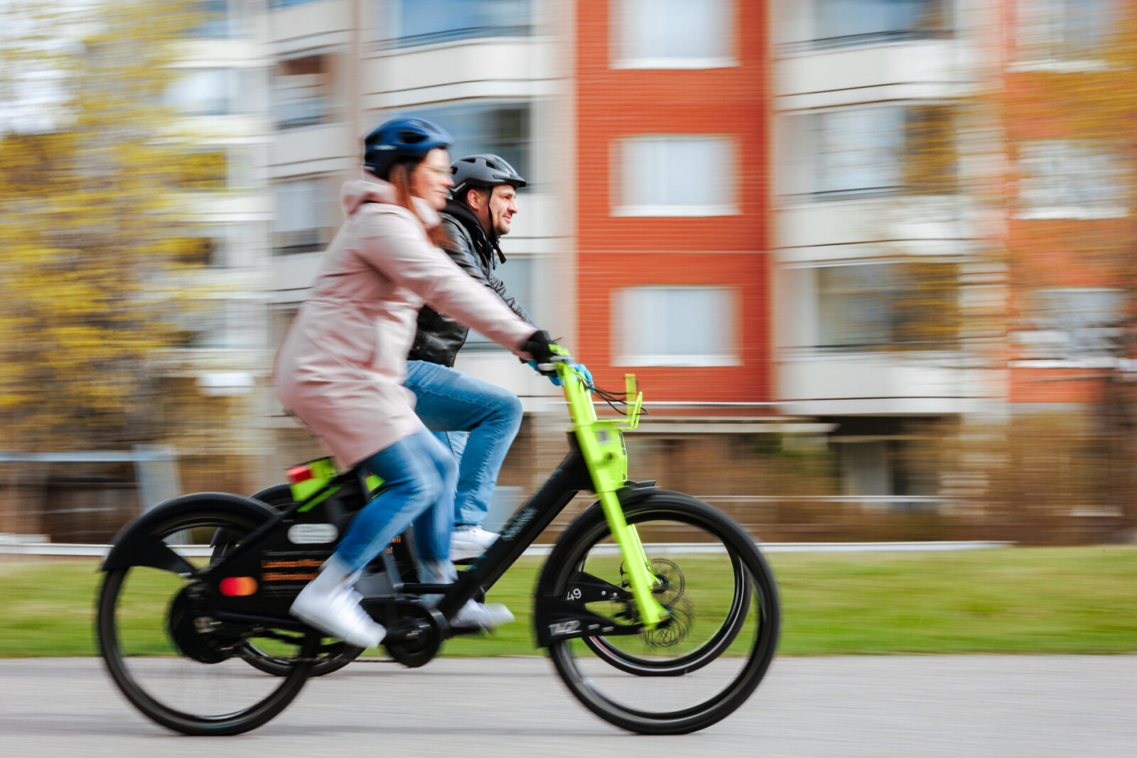 Kaksi henkilöä ajaa kaupunkipyörillä.