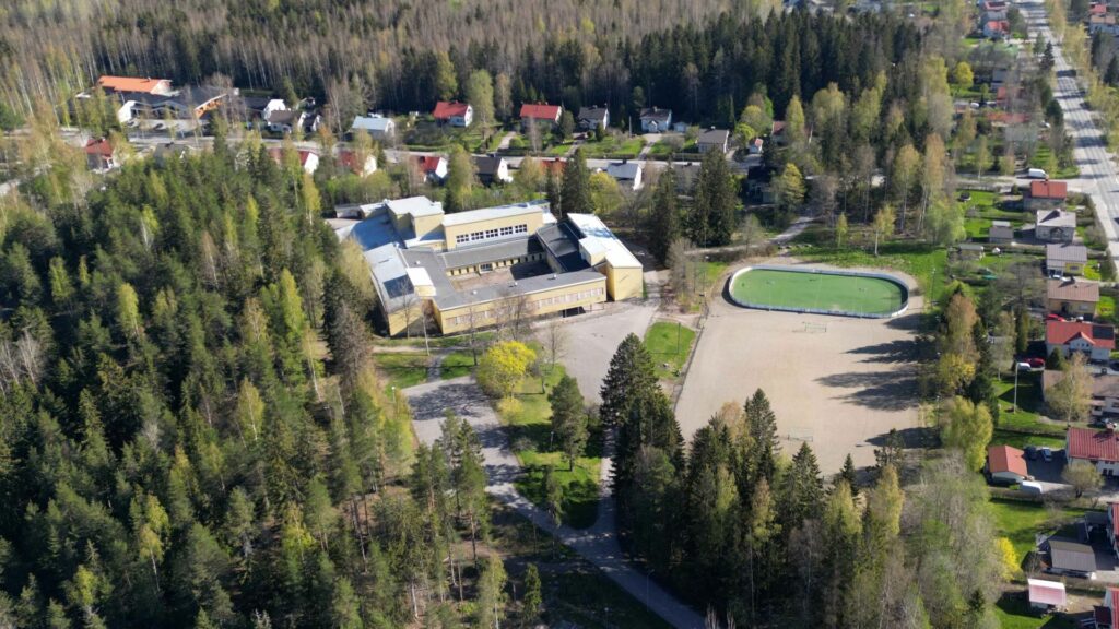 Dronella ilmasta kuvattu valokuva Salinkallion koulusta, sen viereisestä urheilukentästä ja puistosta sekä läheisestä omakotitaloalueesta.
