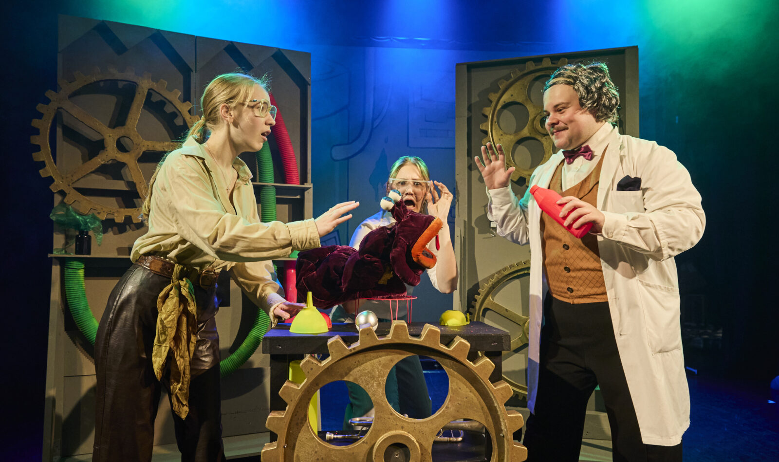 Kuvassa käynnissä Lahden Kesänäyttämön merimonsterit, jossa on kolme ihmistä, lavasteta ja keskellä pieni monsterinukke.